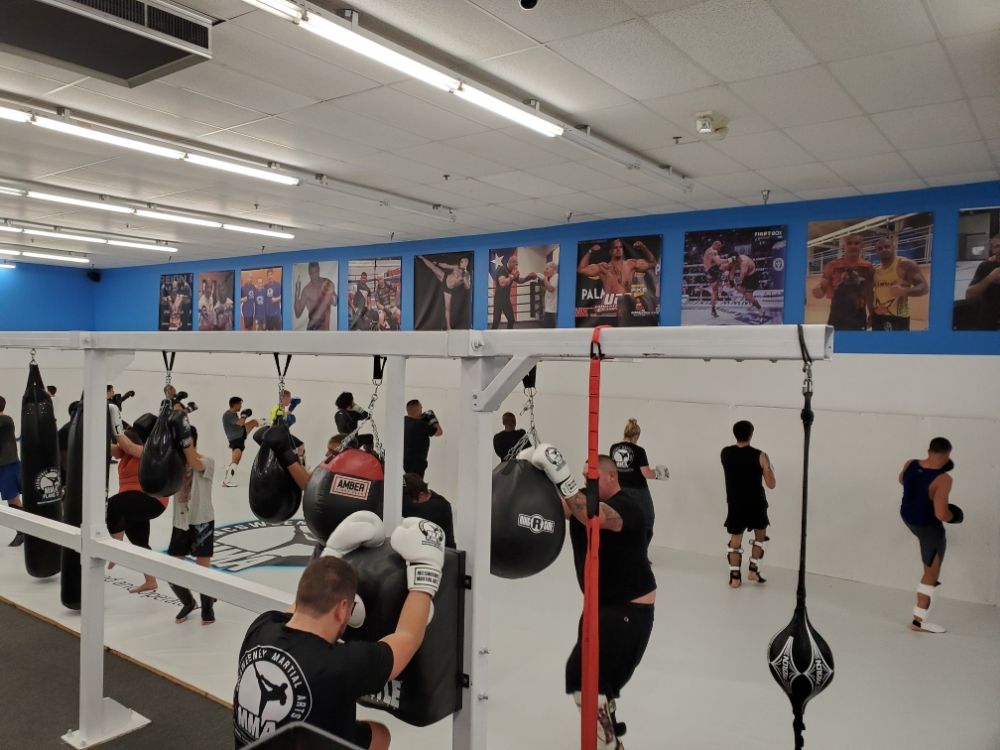 Group training on the gym floor with heavy bags